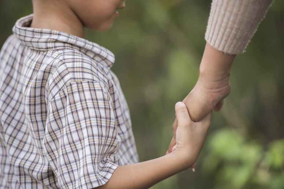 criança segurando a mão da mãe