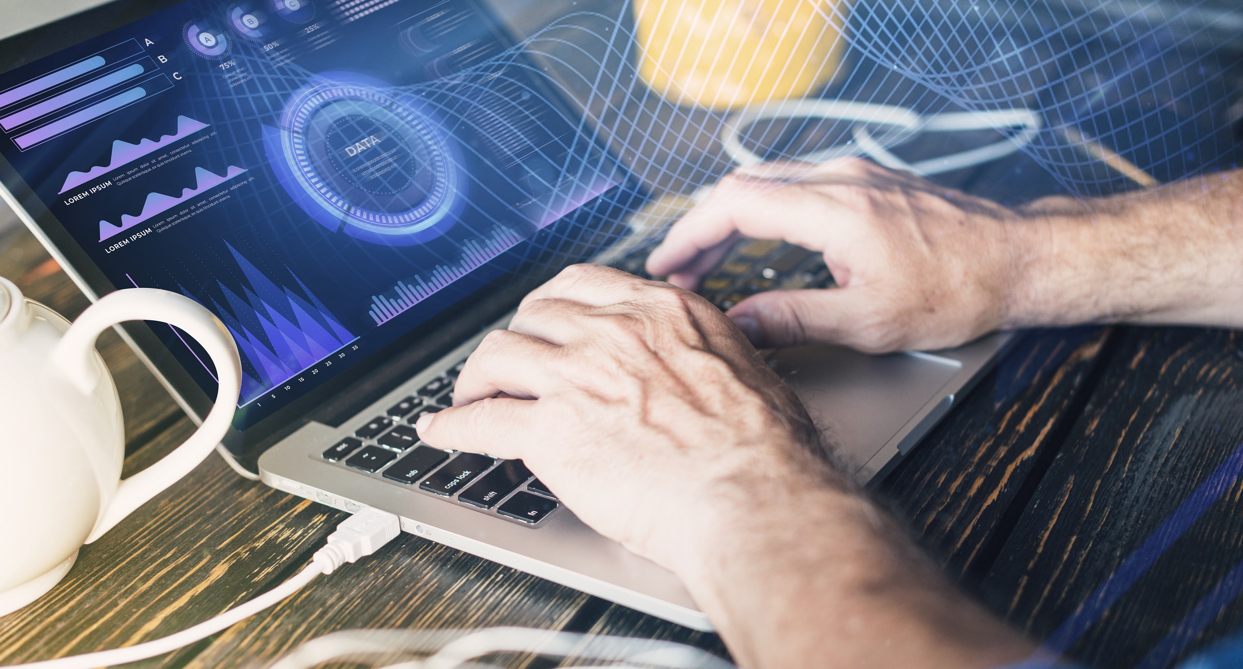 Mãos, aparentemente masculinas, digitando no teclado de um notebook que mostra uma tela com elementos que representam dados