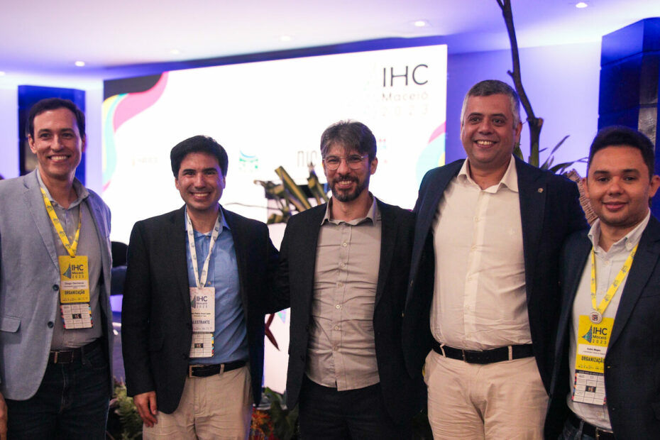 Integrantes do NEES, junto a palestrante do evento IHC, posam para foto sorridentes