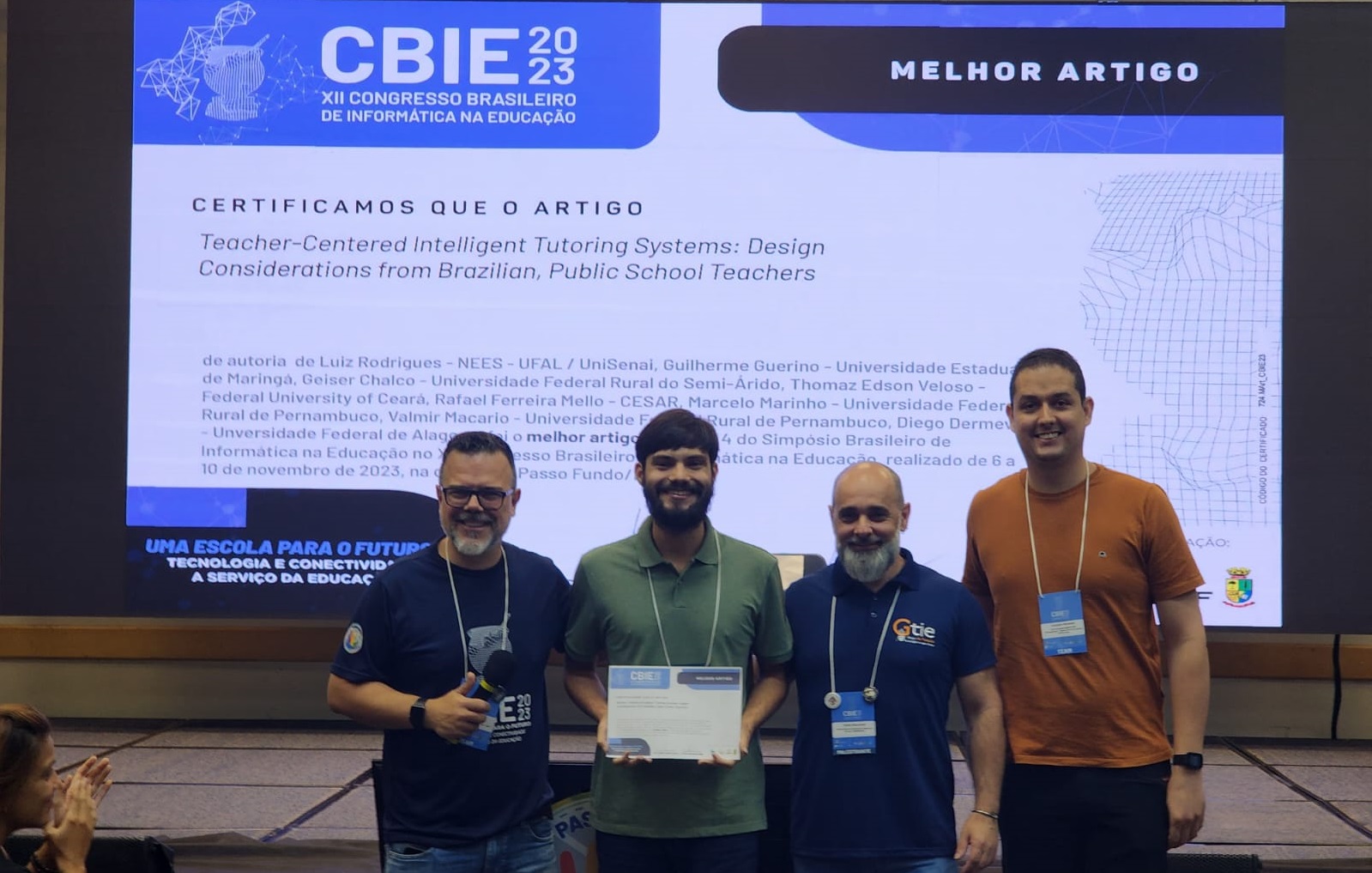 Autores do artigo premiado posam para a foto segurando o certificado