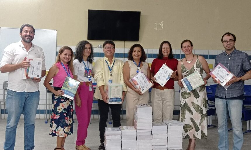 Representantes do NEES e profissionais da educação durante a entrega dos livros