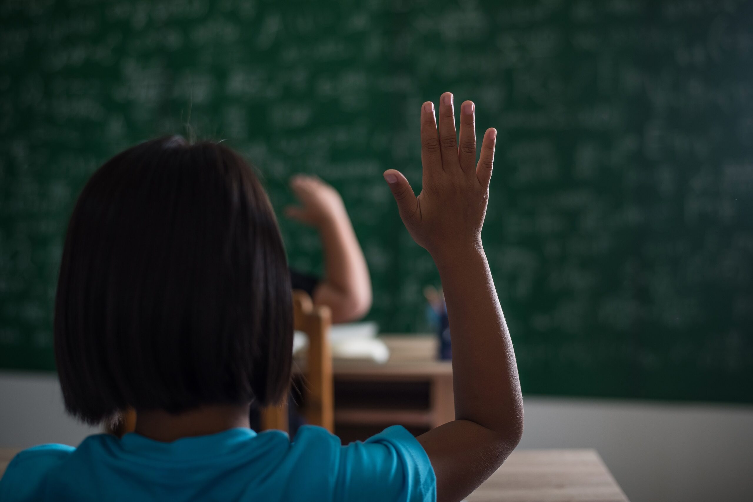 criança levantando a mão na sala de aula