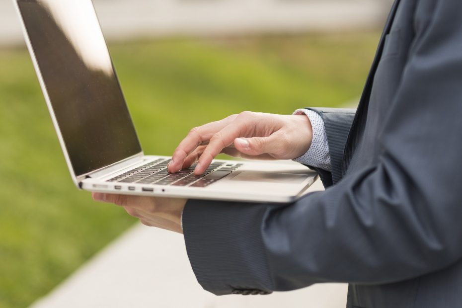 Homem de terno mexendo em notebook