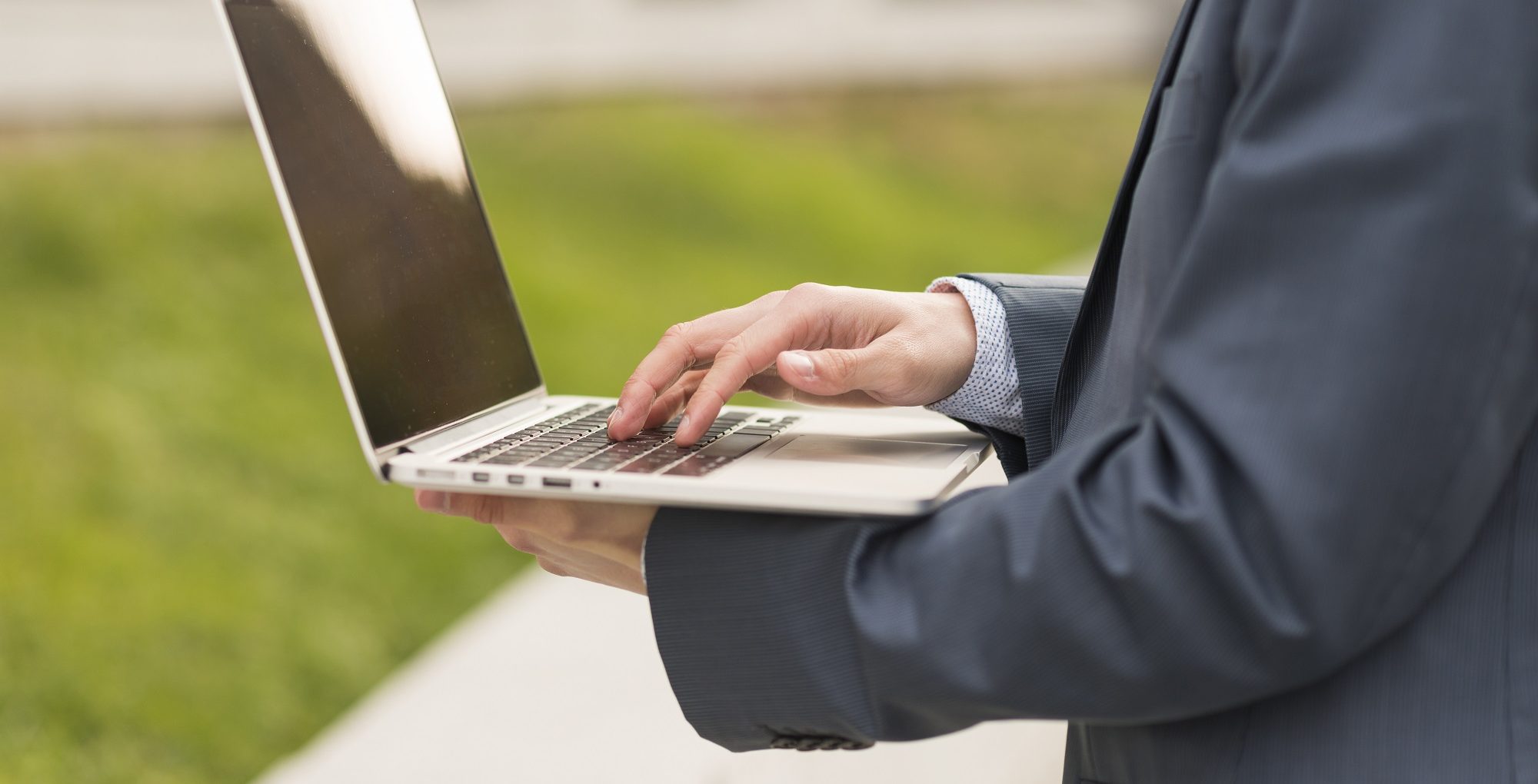 Homem de terno mexendo em notebook