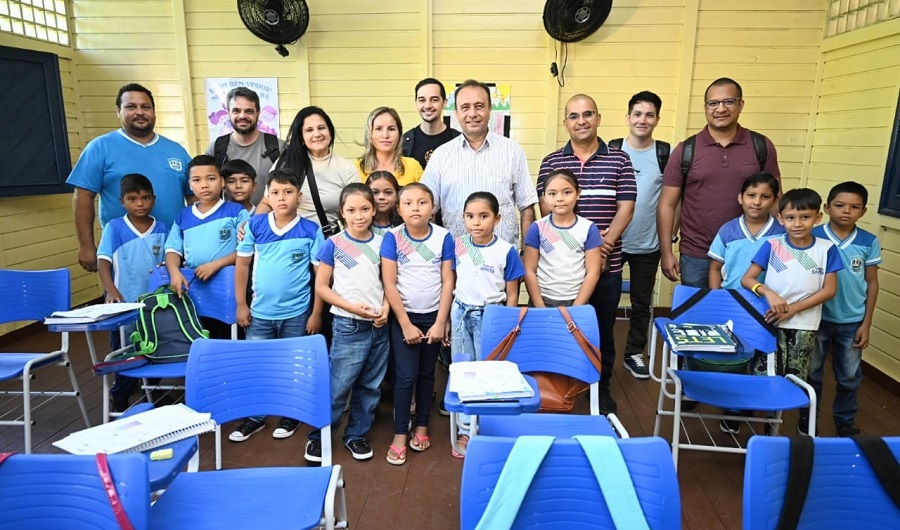 Membros do NEES, junto a professoras, alunas e alunos do ensino fundamental posam para a foto