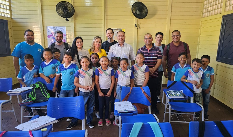 Membros do NEES, junto a professoras, alunas e alunos do ensino fundamental posam para a foto